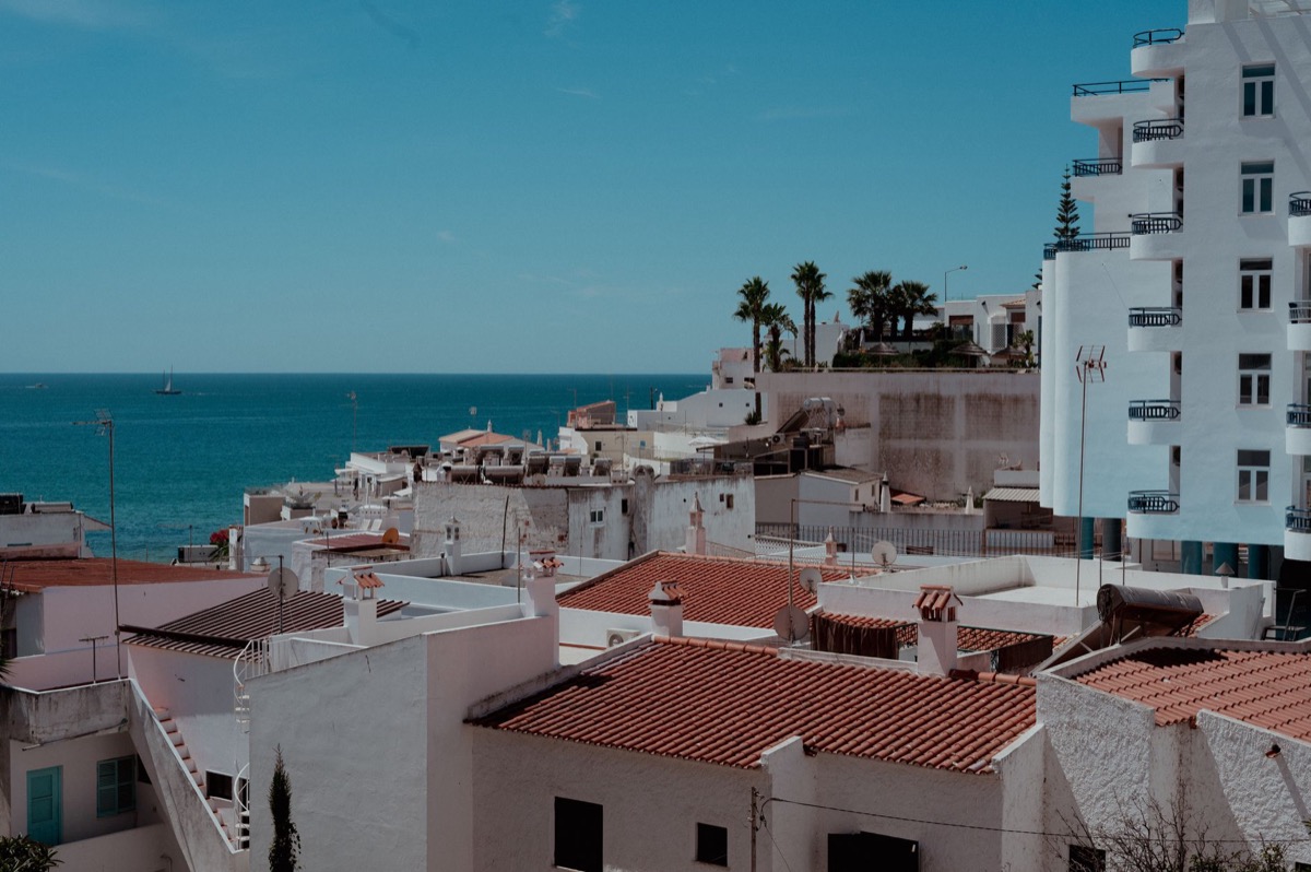 A charming Algarve townscape in Portugal with white buildings and an ocean view.