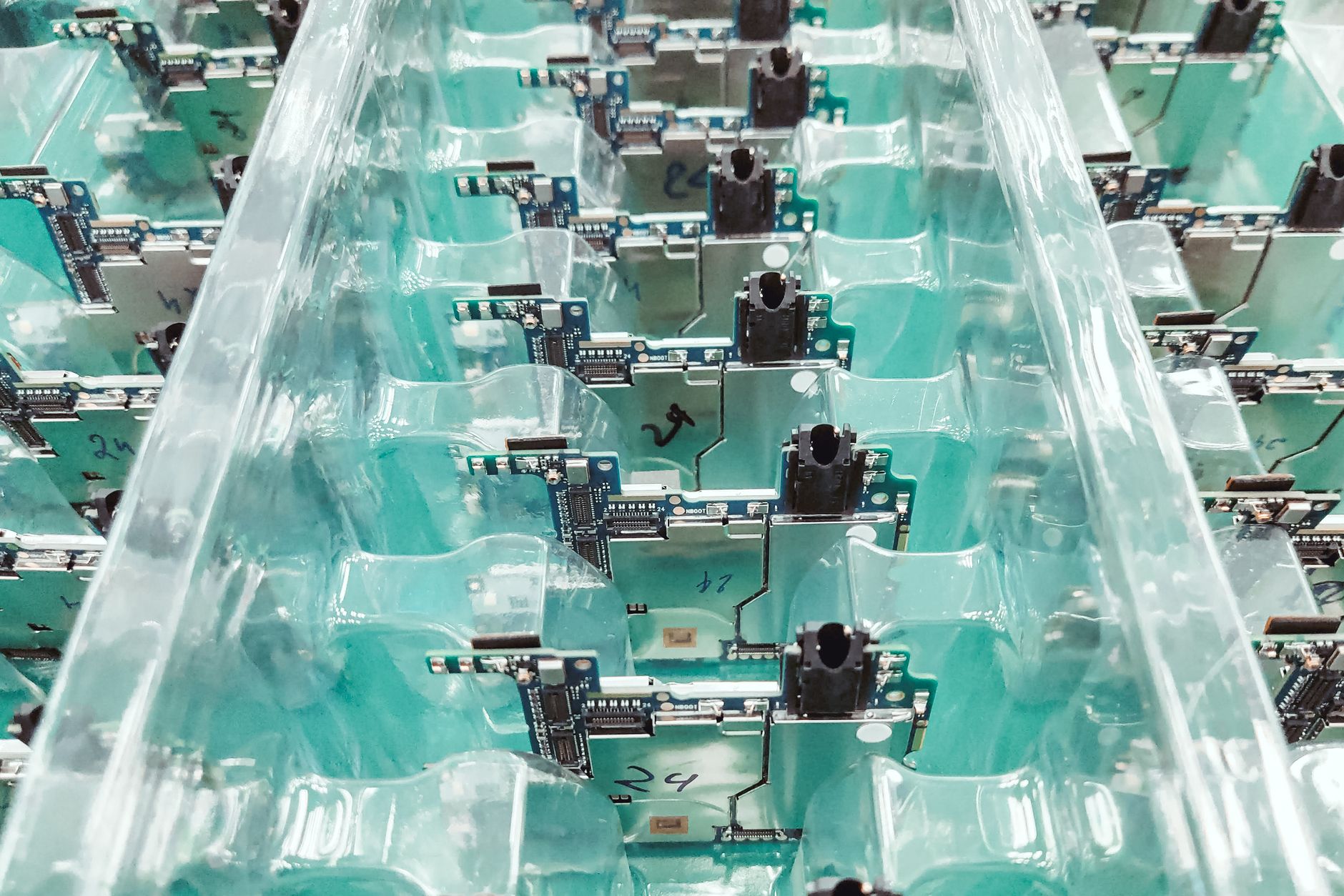 Organized electronic circuit boards in production.