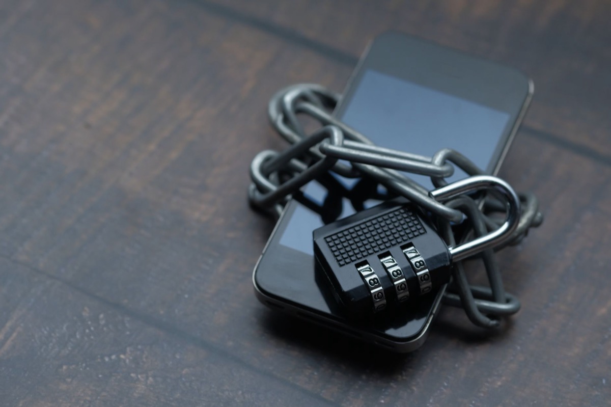 A smartphone wrapped in a chain with a padlock, symbolizing a locked device.
