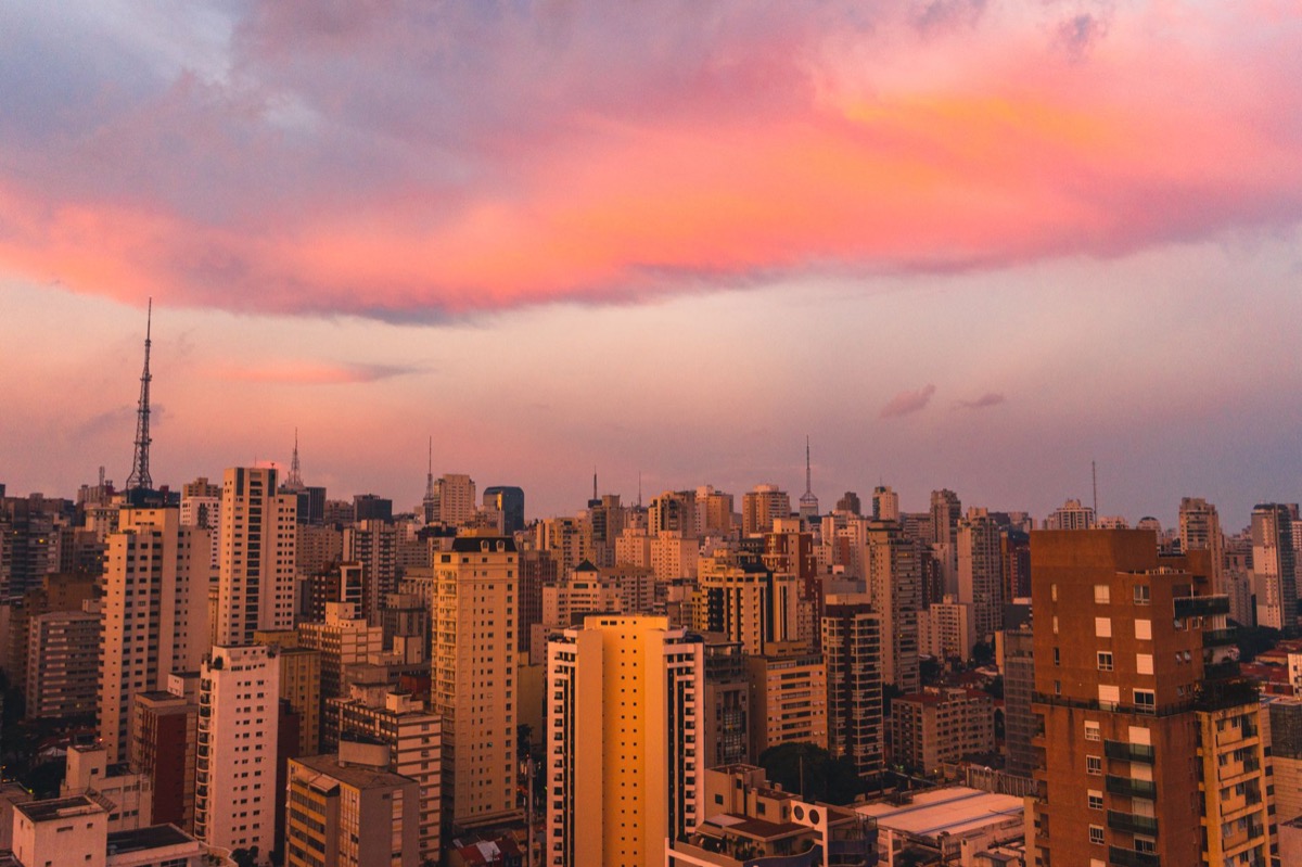 The Sao Paulo skyline at dusk with vibrant pink and orange clouds.