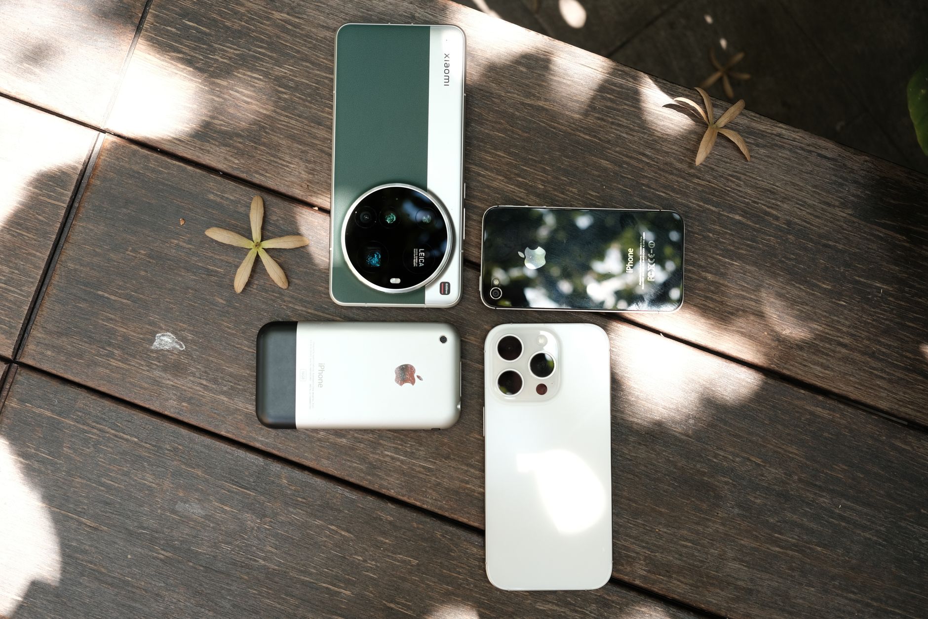 Assorted smartphones laid out on a wooden table.