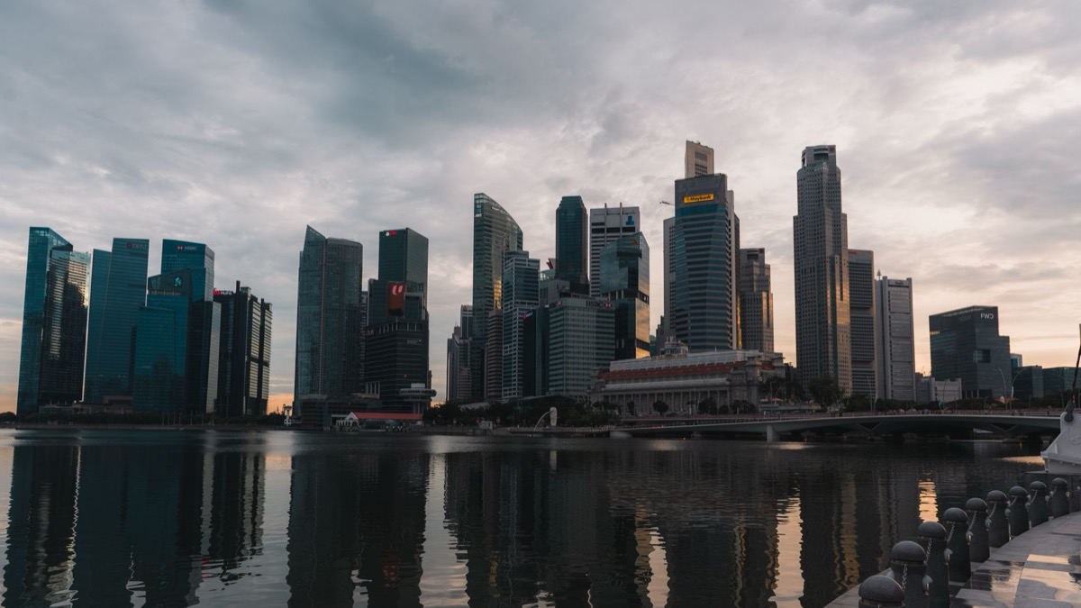 The Singapore skyline reflecting on the waterfront at dusk.