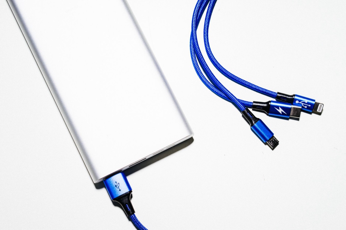 A minimalist shot of a power bank with blue USB charging cables on a white background.