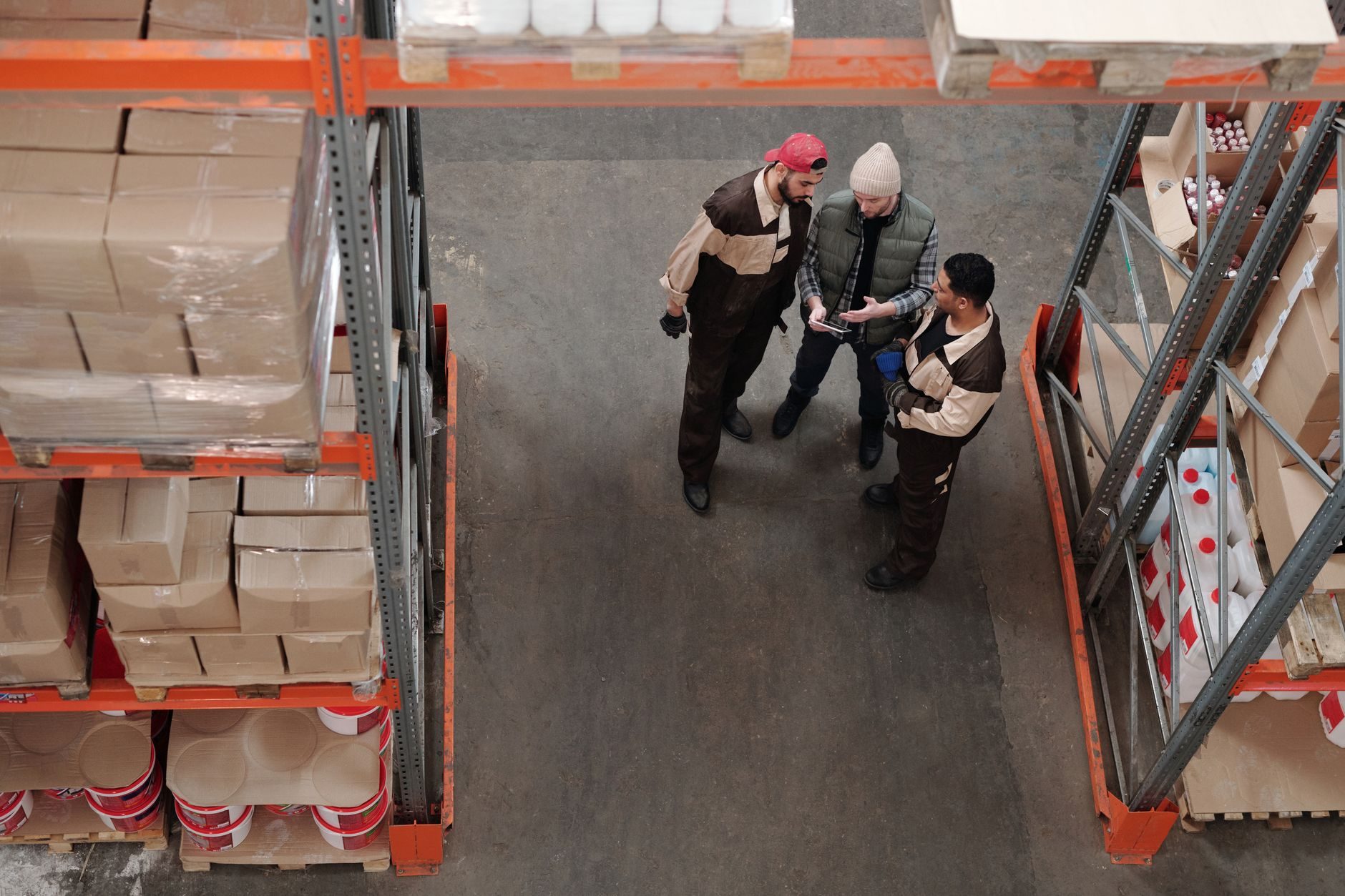 Workers inspecting boxes of stock in a wholesale warehouse during an incoming-goods inspection.